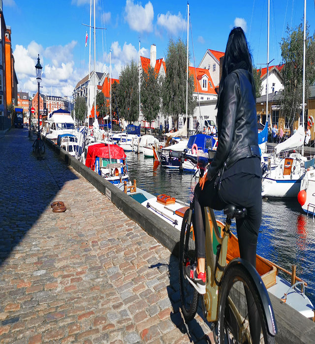 girl on bike in christianiahavn yachts harbour