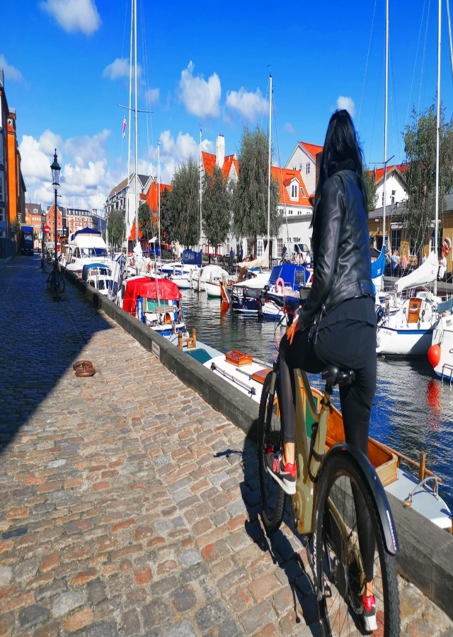 girl on bike in christianiahavn yachts harbour